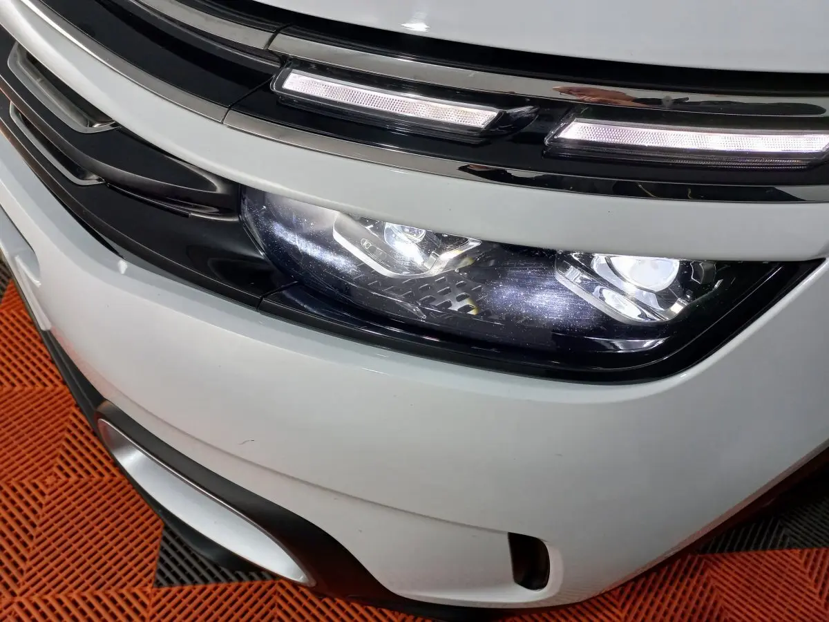Gros plan sur le phare avant droit blanc du Citroën C5 Aircross 2020 avec éclairage LED et calandre noire.