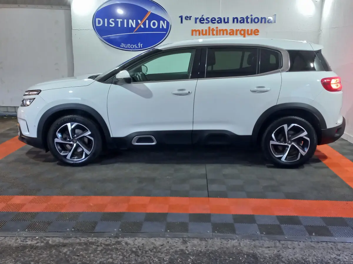 Profil côté gauche d'un Citroën C5 Aircross blanc 2020 avec jantes alliage et protections noires basses.