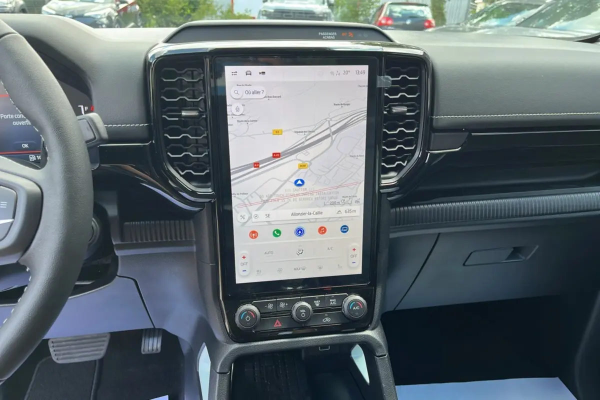 Vue intérieure centrée sur la console centrale tactile verticale du Ford Ranger gris zen avec volant multifonctions partiel visible.