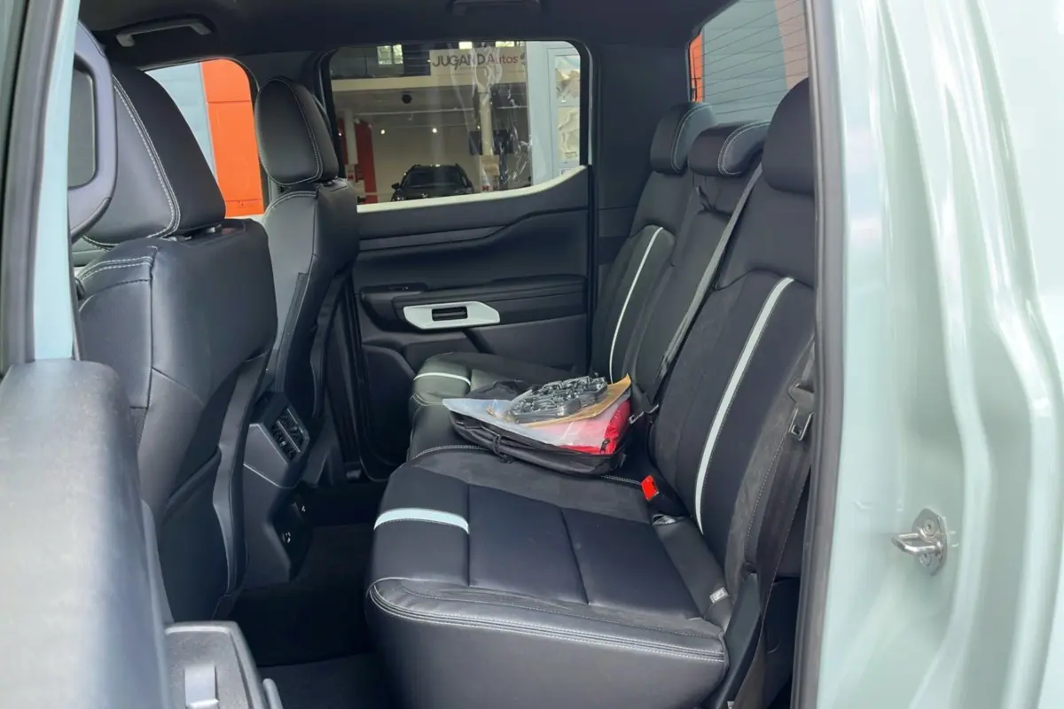 Vue intérieure côté droit du Ford Ranger 2.3 PHEV gris zen, montrant la banquette arrière en cuir noir avec surpiqûres claires.