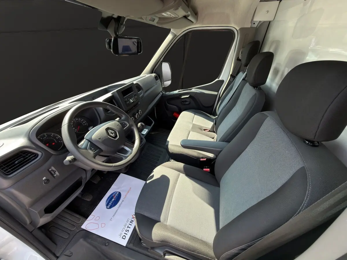 Vue intérieure côté conducteur du Renault Master 2024, montrant le tableau de bord et les sièges gris et noirs.