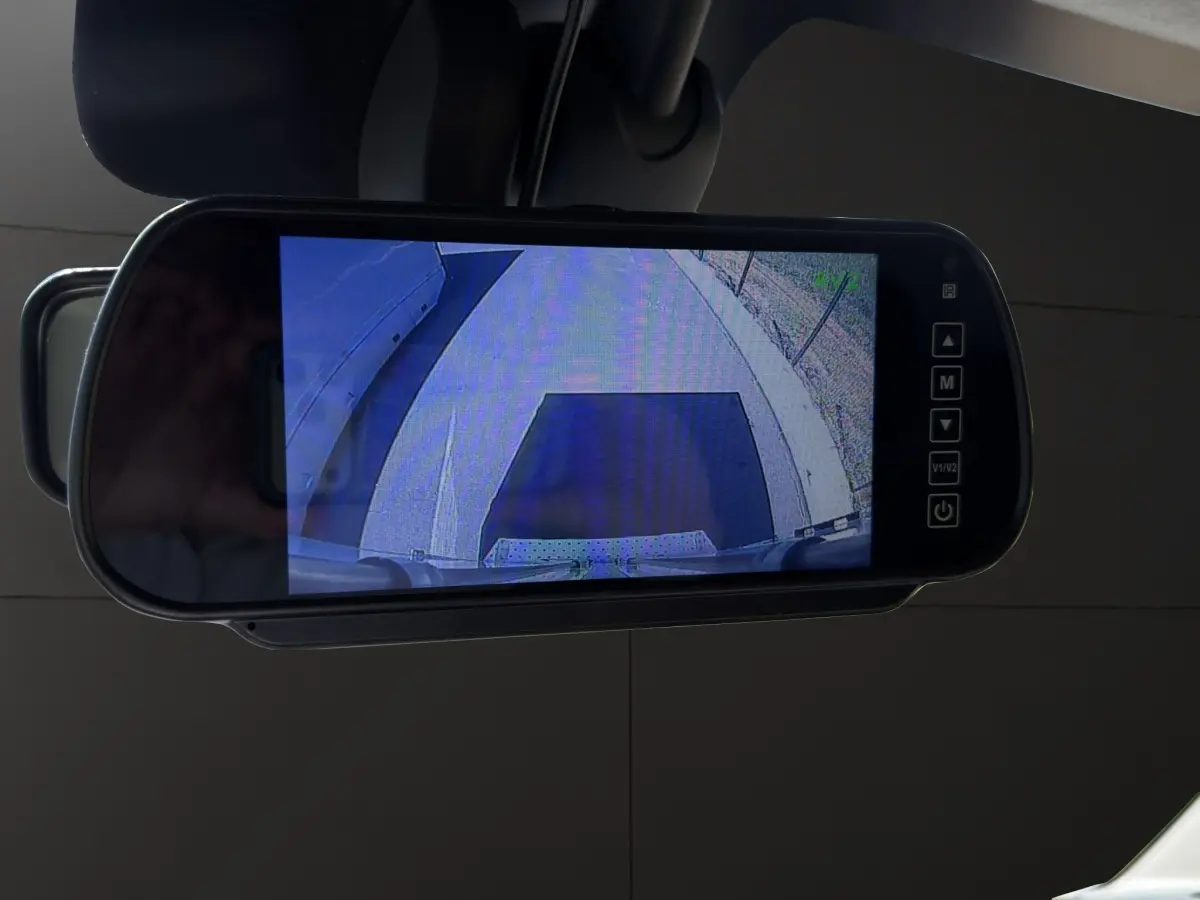 Écran de caméra de recul intégré au rétroviseur intérieur du Renault Master blanc, vue arrière du véhicule.
