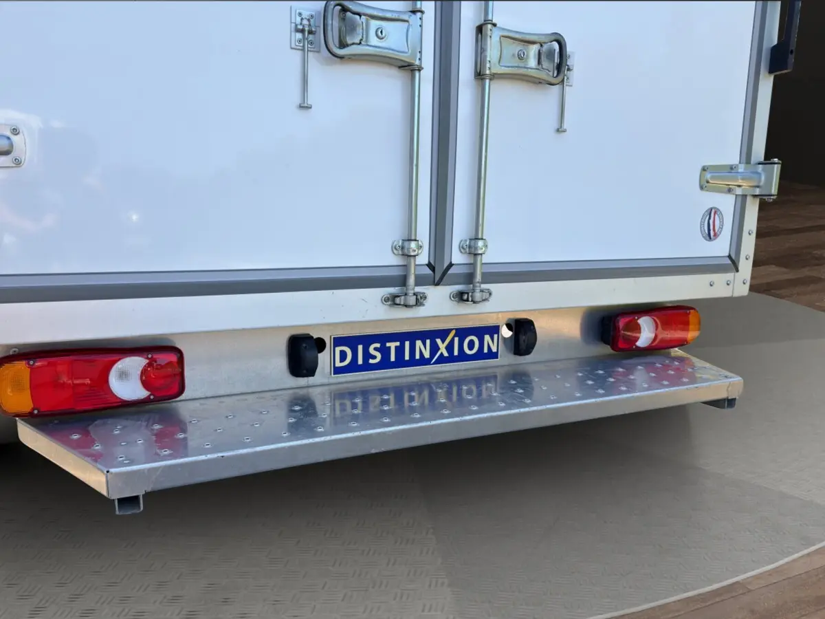Vue rapprochée arrière du Renault Master blanc montrant les portes arrière fermées et le pare-chocs métallique avec feux intégrés.