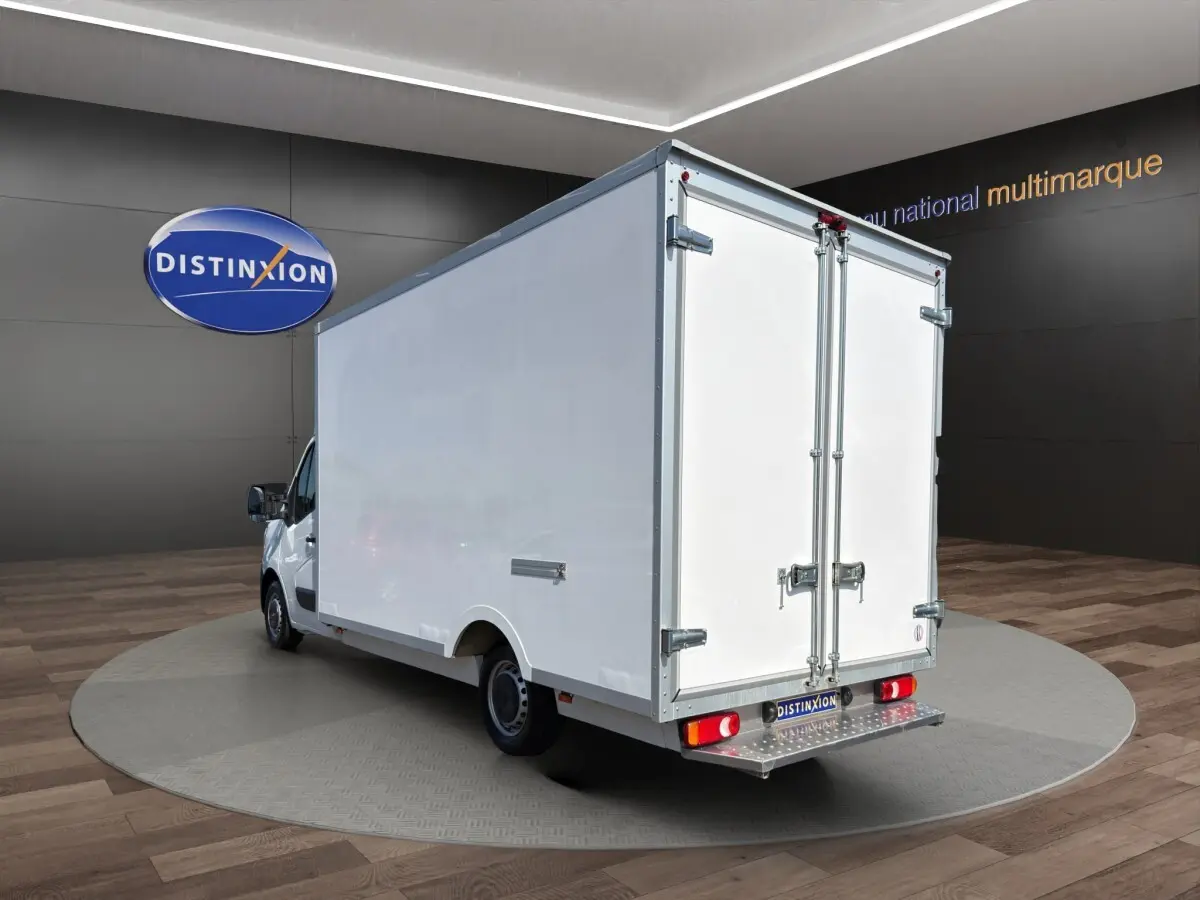 Renault Master blanc vu en 3/4 arrière droit, caisse fermée avec portes arrière battantes et marchepied métallique.