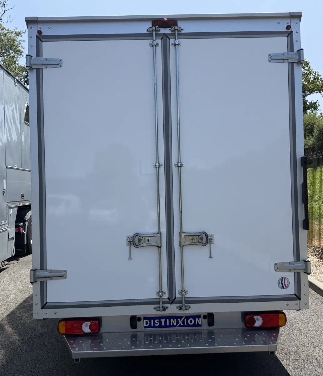 Vue arrière d’un utilitaire Renault Master blanc avec caisse fermée et plaque Distinxion visible.