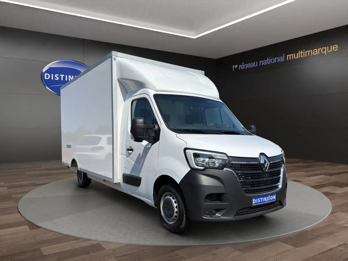 Renault Master blanc en 3/4 avant droit, avec caisse de livraison volumineuse et calandre noire distinctive.