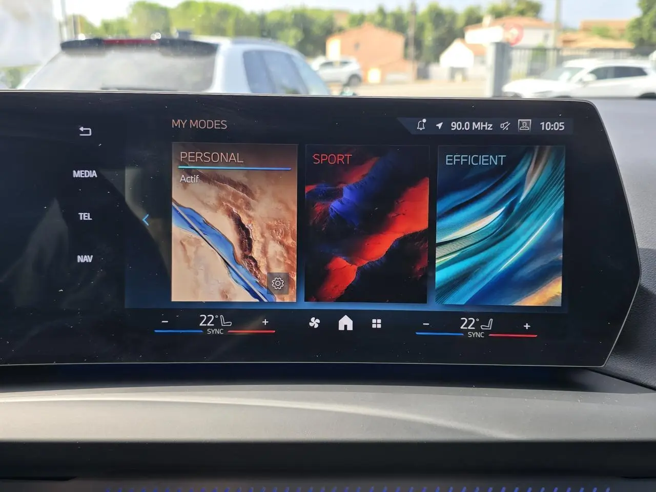 Écran incurvé BMW Live Cockpit affichant les modes de conduite Personal, Sport et Efficient dans une BMW Série 1 2024.