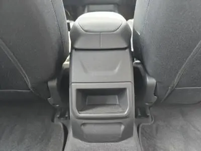 Vue rapprochée de l'accoudoir central arrière gris anthracite entre les sièges avant en tissu de la BMW Série 1 F70 120D M Sport.