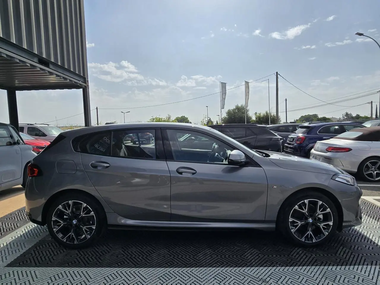 BMW Série 1 120D M Sport gris Skyscraper vue de profil côté gauche, avec jantes alliage 18 pouces bicolores.