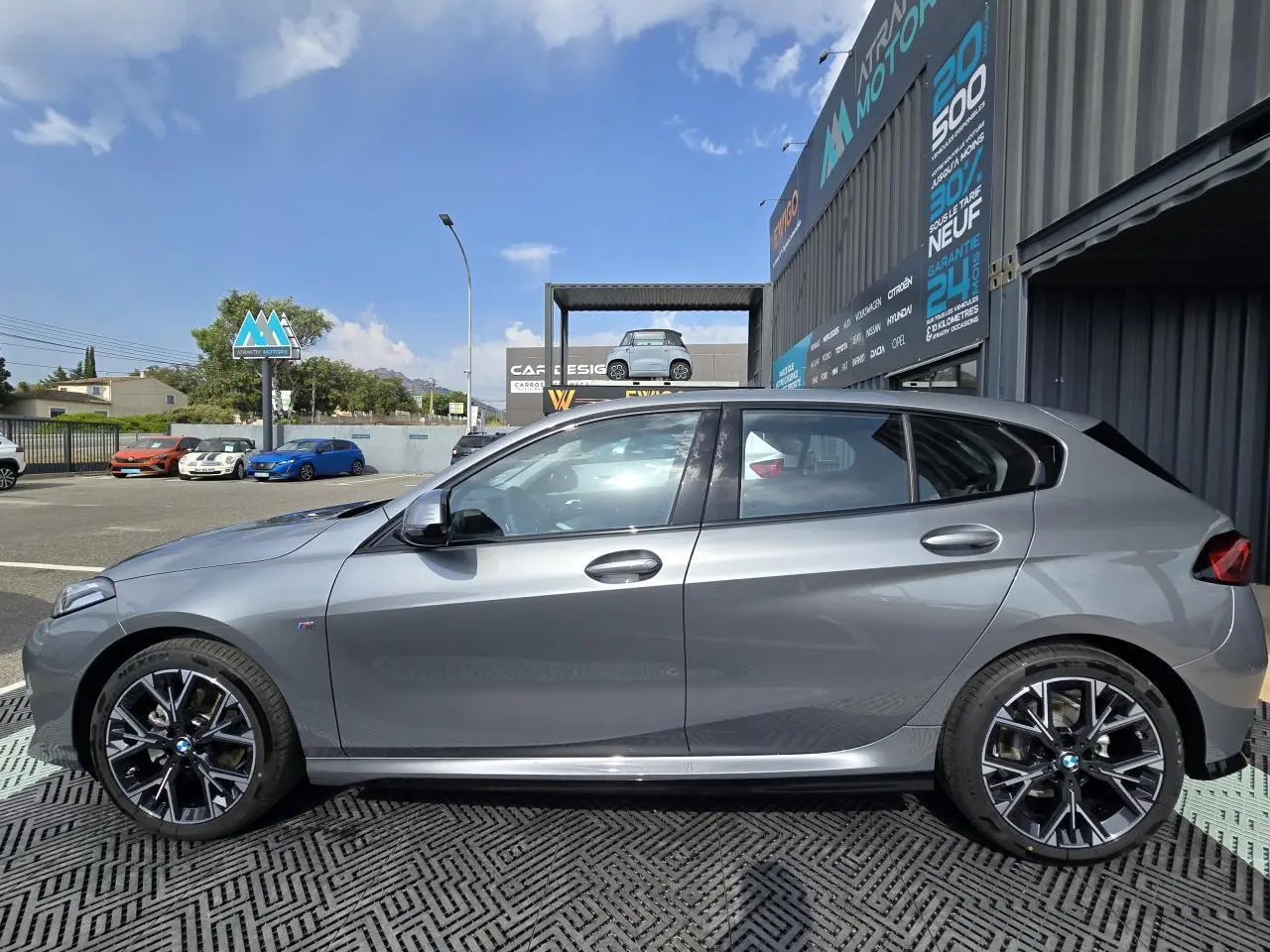 BMW Série 1 F70 gris Skyscraper vue de profil côté gauche, avec jantes alliage 18 pouces M Sport.
