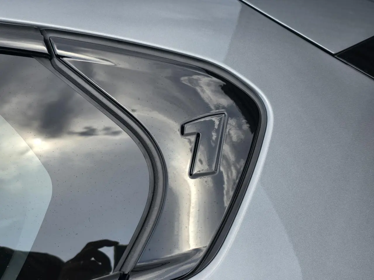 Détail du logo "1" sur la vitre arrière droite de la BMW Série 1 gris Skyscraper métallisé.