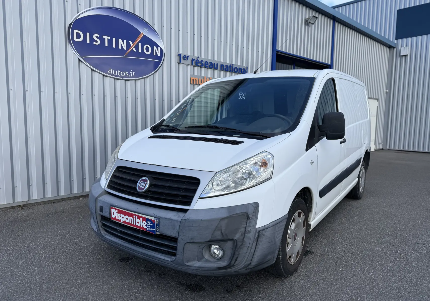 Fiat Scudo Fourgon blanc en 3/4 avant droit, fourgon utilitaire avec pare-chocs avant gris et logo Fiat visible.