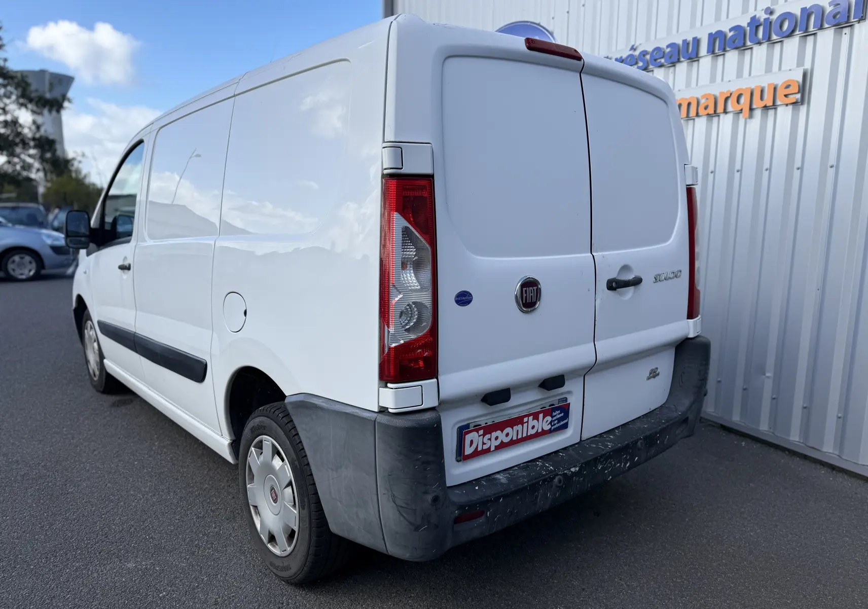 Vue 3/4 arrière droite d’un FIAT Scudo Fourgon blanc de 2015 avec portes arrière battantes et pare-chocs noir.