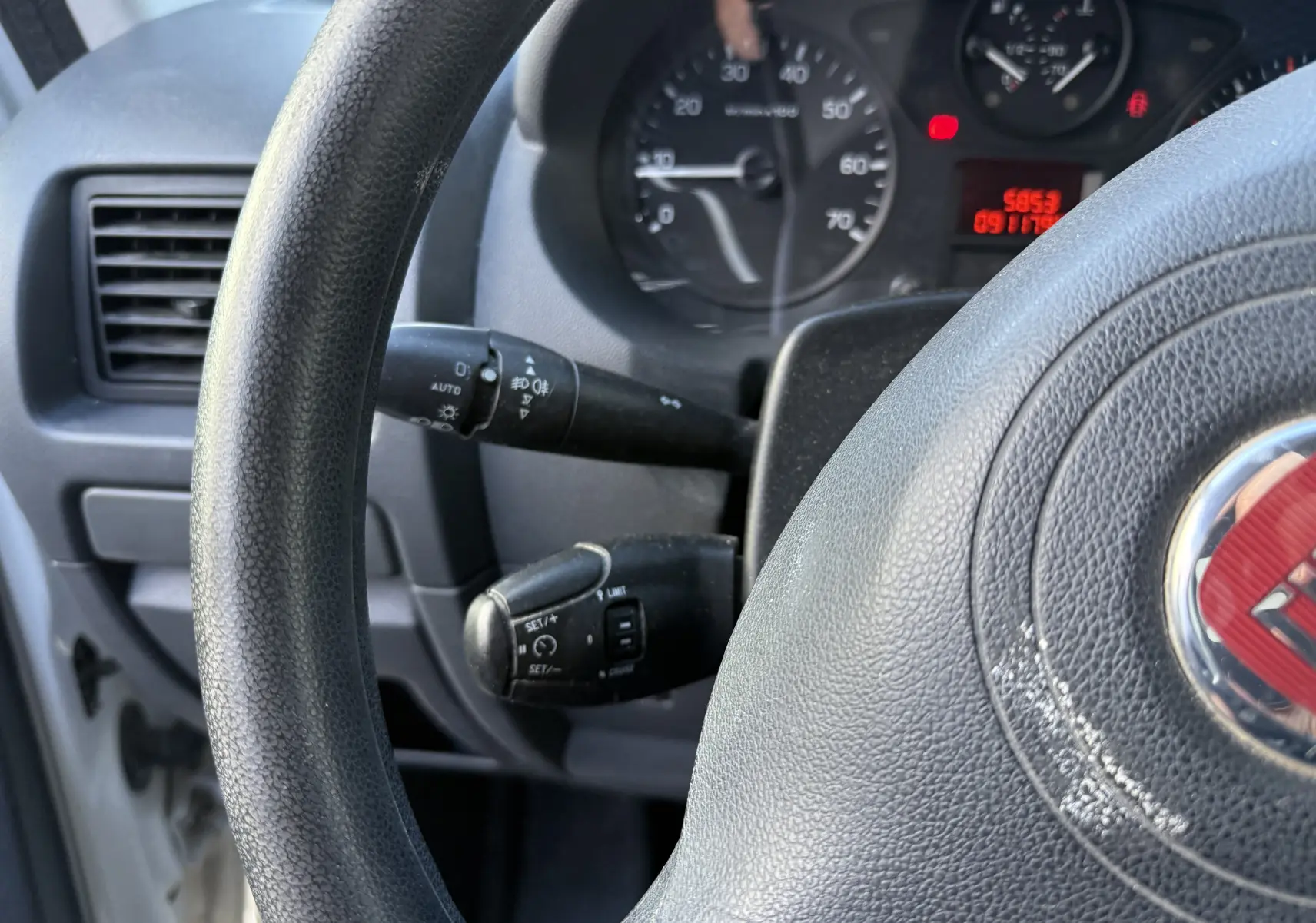 Gros plan sur le volant noir et le tableau de bord du Fiat Scudo Fourgon blanc, avec compteurs et commandes visibles.