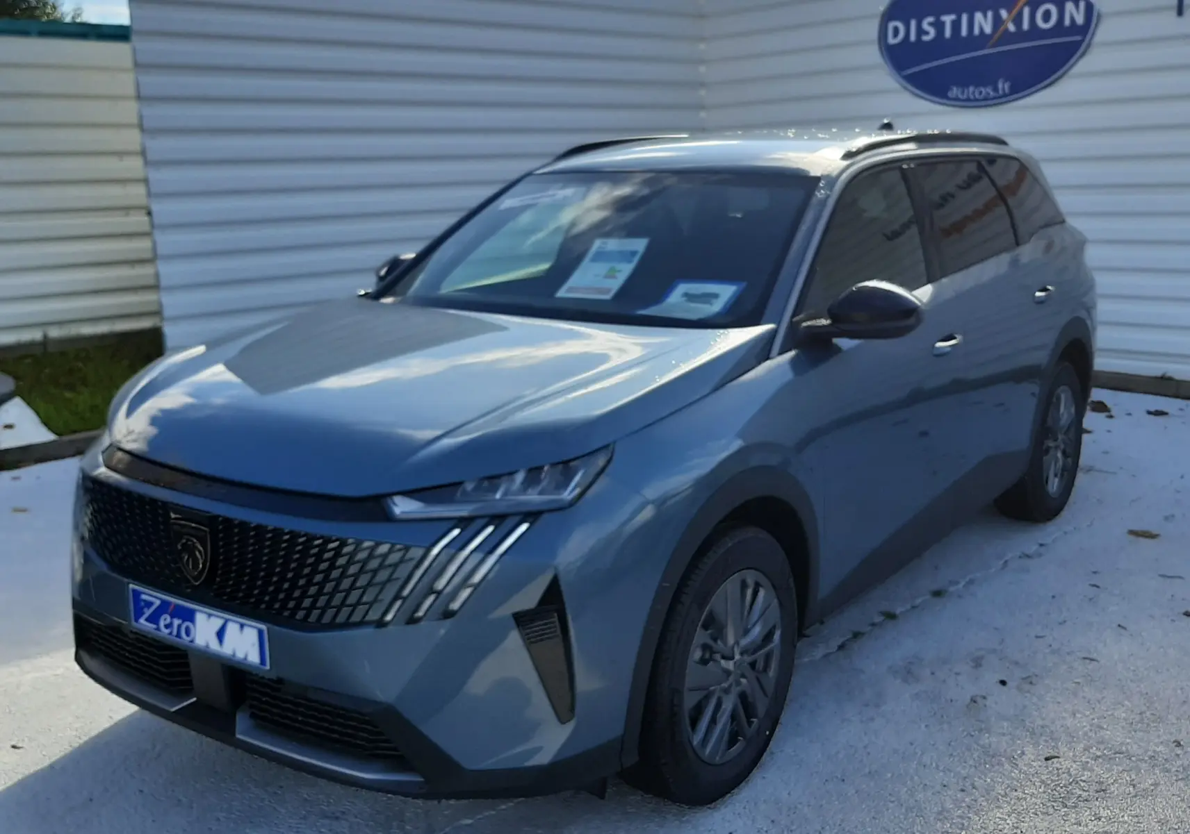 Peugeot 5008 bleu Ingaro vue 3/4 avant droit, avec calandre noire et phares LED distinctifs.