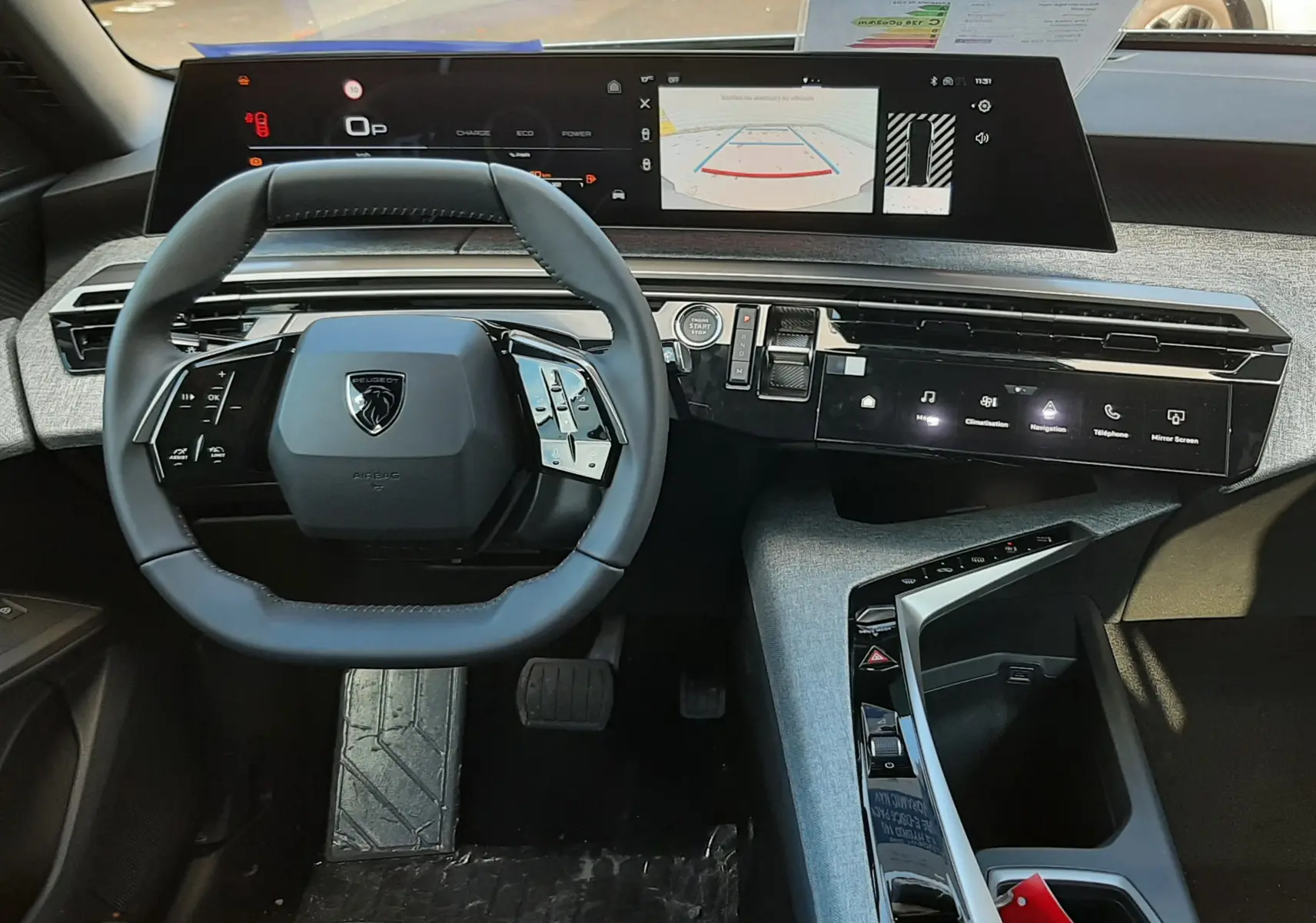 Intérieur du Peugeot 5008 2025, vue du poste de conduite avec volant compact et double écran numérique panoramique.
