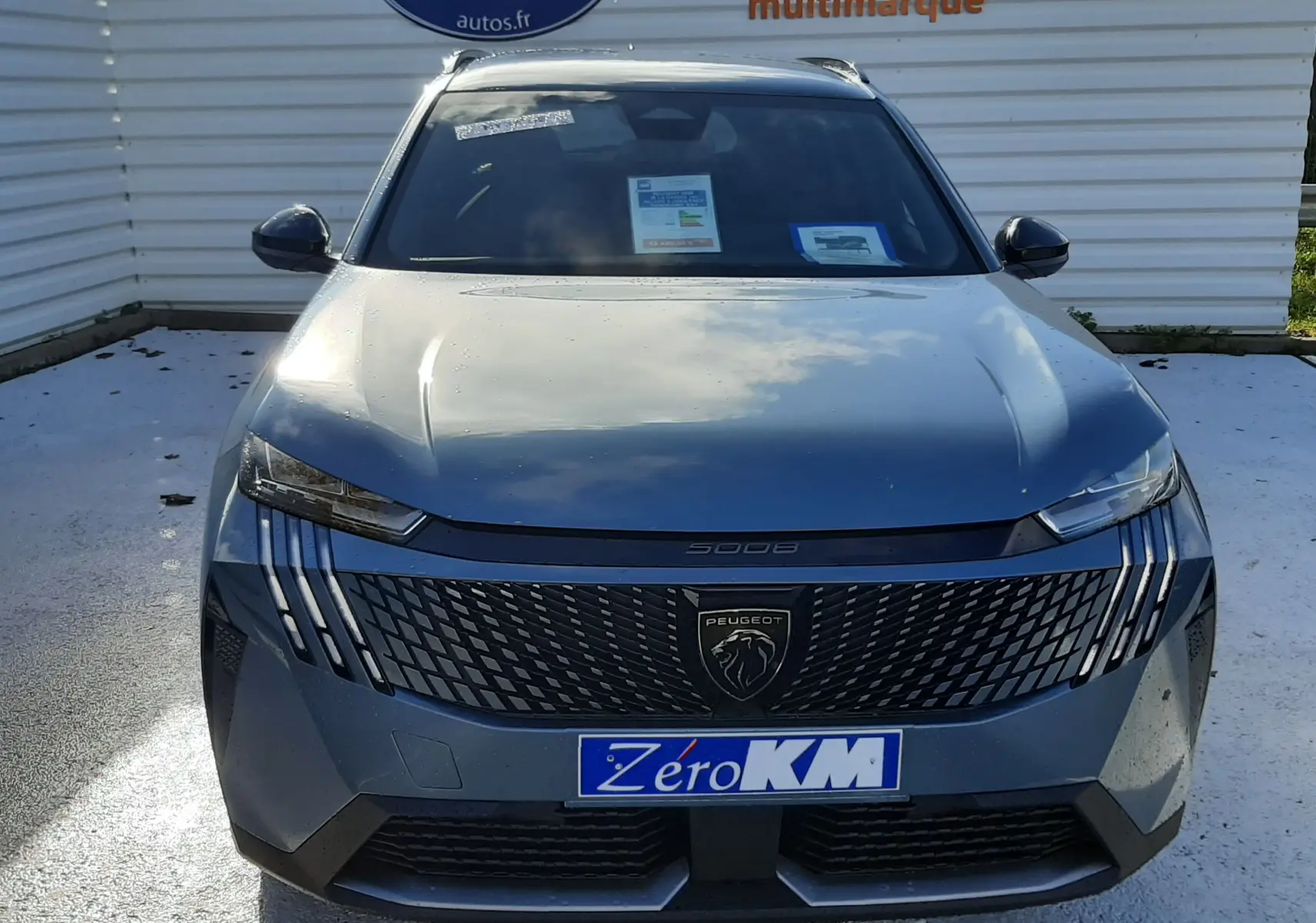 Vue frontale d'un Peugeot 5008 bleu Ingaro 2025 avec calandre noire et logo lion distinctif.