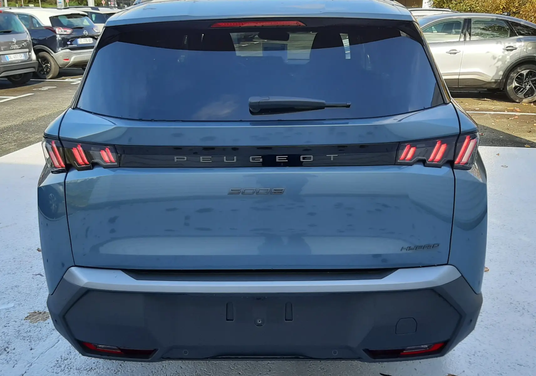 Vue arrière d'un Peugeot 5008 bleu Ingaro 2025 avec feux arrière LED caractéristiques et hayon fermé.