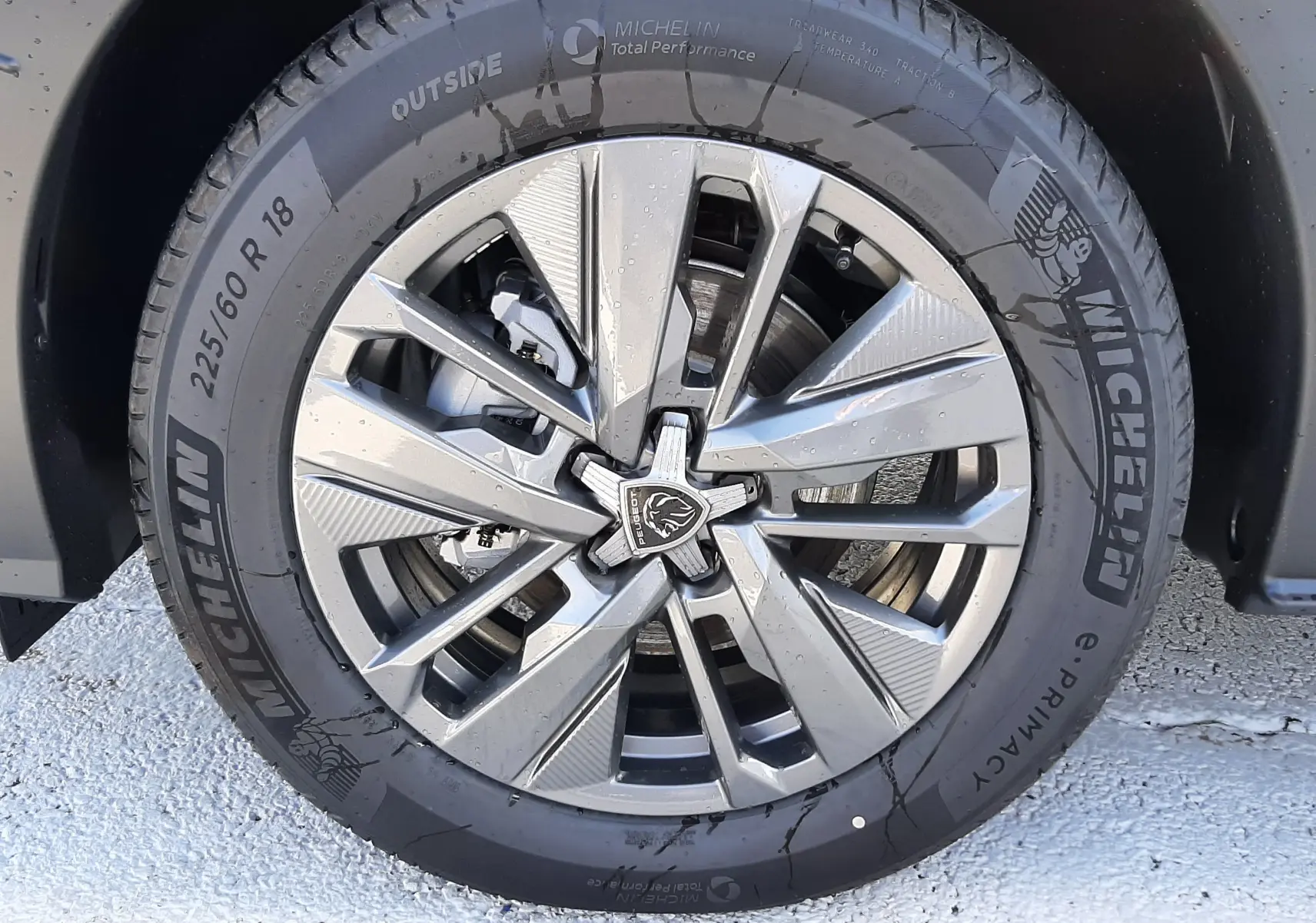 Gros plan sur la jante alliage moderne et le pneu Michelin du PEUGEOT 5008 bleu Ingaro, côté avant droit.