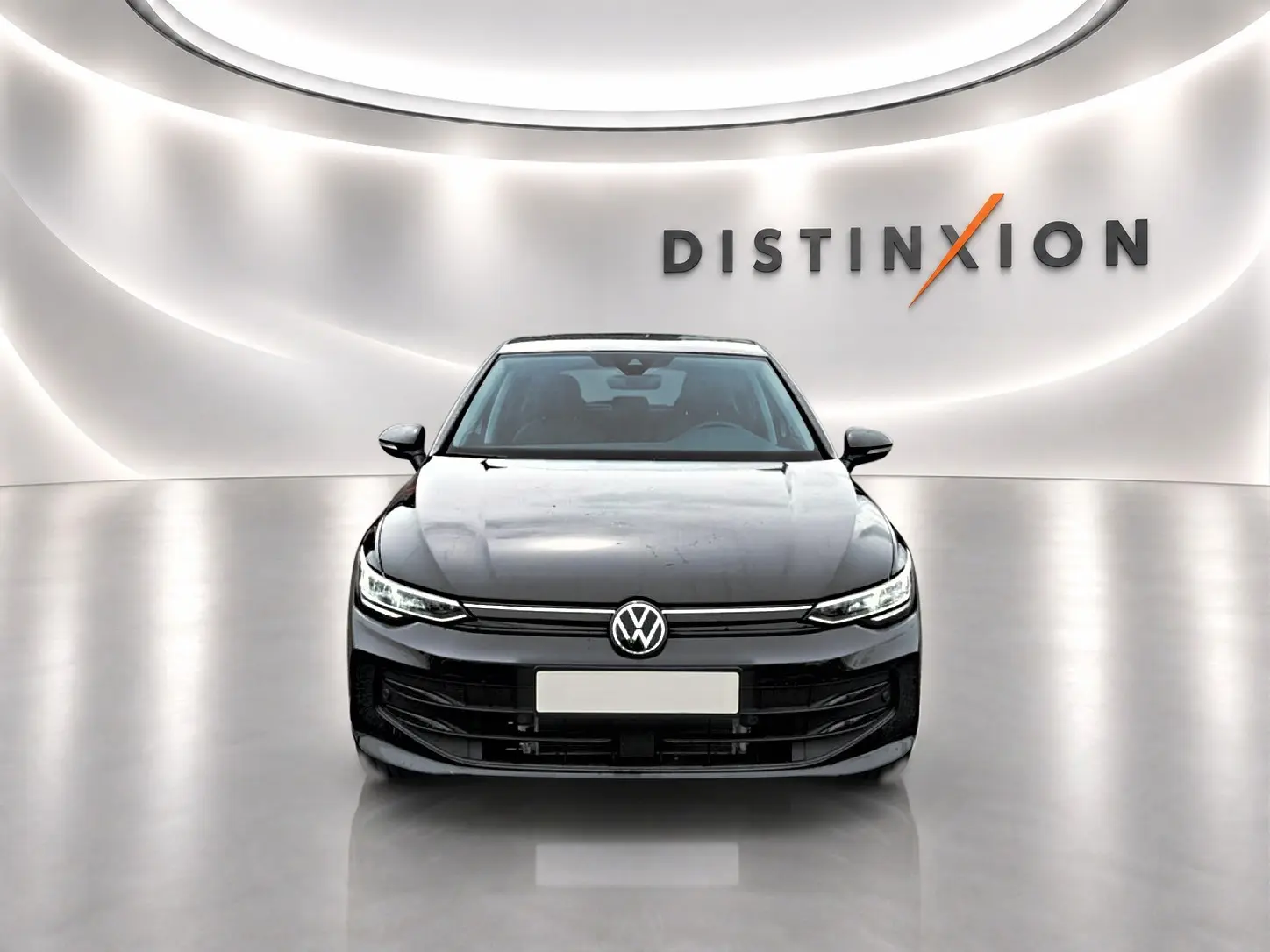 Vue frontale d'une Volkswagen Golf noire 2026 dans un showroom lumineux avec logo Distinxion en arrière-plan.