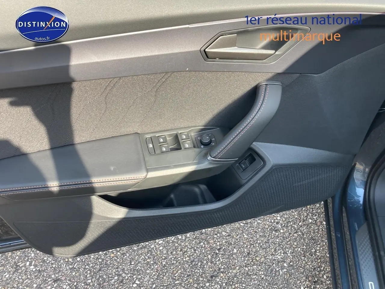 Vue du panneau de porte avant gauche gris magnétique du CUPRA Formentor 1.5 etsi hybrid avec commandes de vitres et rétroviseurs.