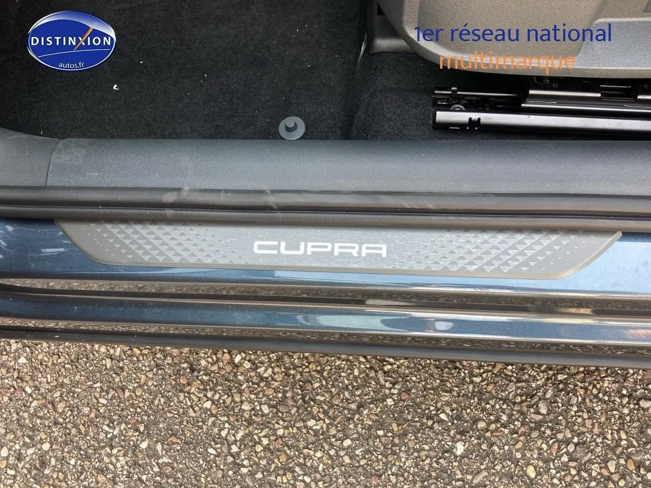 Gros plan sur la plaque de seuil de porte CUPRA gris magnétique côté gauche avec moquette noire intérieure.