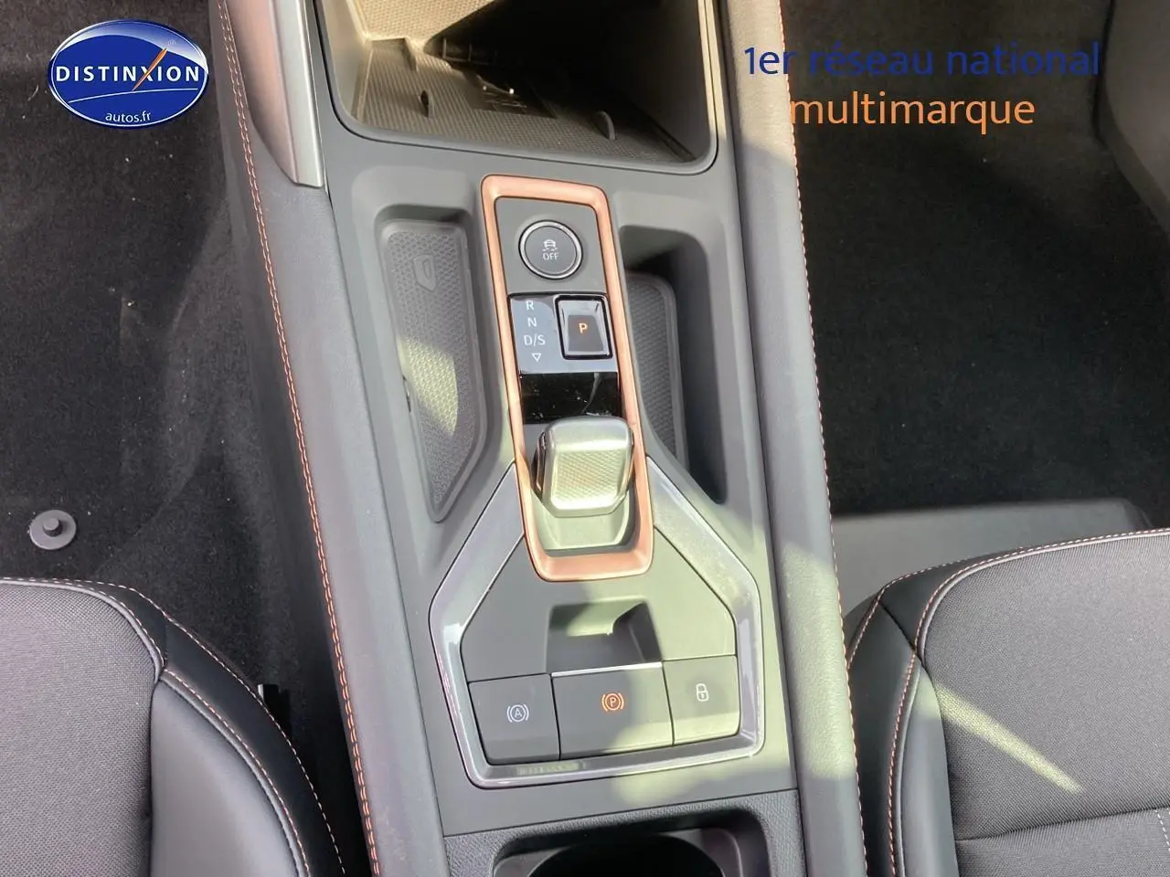 Vue rapprochée de la console centrale du CUPRA Formentor gris magnétique avec levier de vitesse et surpiqûres orange.