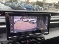 Écran intérieur de la Citroën C3 1.2 turbo 2025 montrant la caméra de recul avec vue arrière du véhicule noir en stationnement.