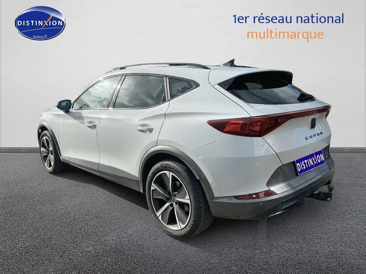 Vue 3/4 arrière droite d'un CUPRA Formentor blanc 2023 avec jantes alu et attelage visible.