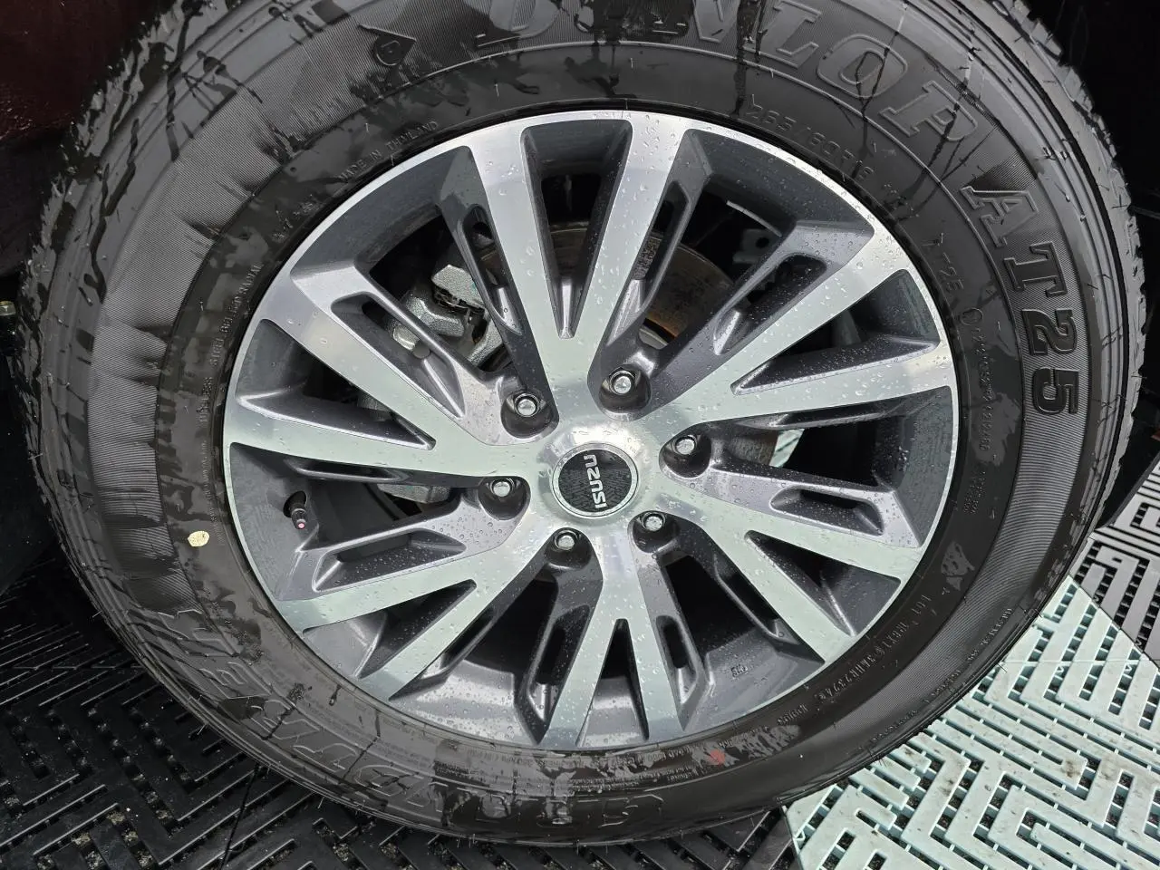 Vue rapprochée de la roue arrière gauche du pick-up Isuzu D-MAX orange métallisé avec jante alliage 18 pouces machining.