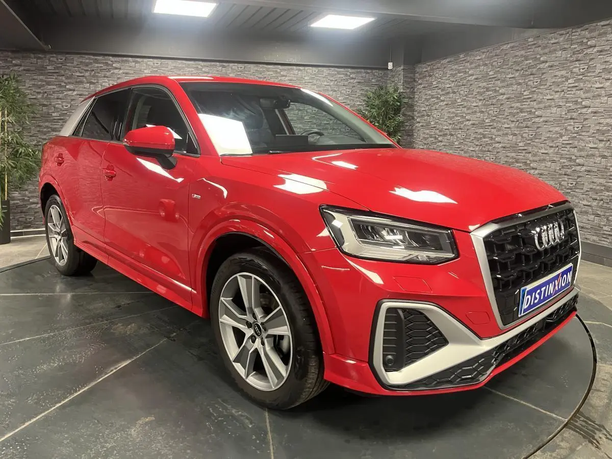 Audi Q2 rouge métallisé vue 3/4 avant droit avec jantes sport 5 branches et calandre noire distinctive