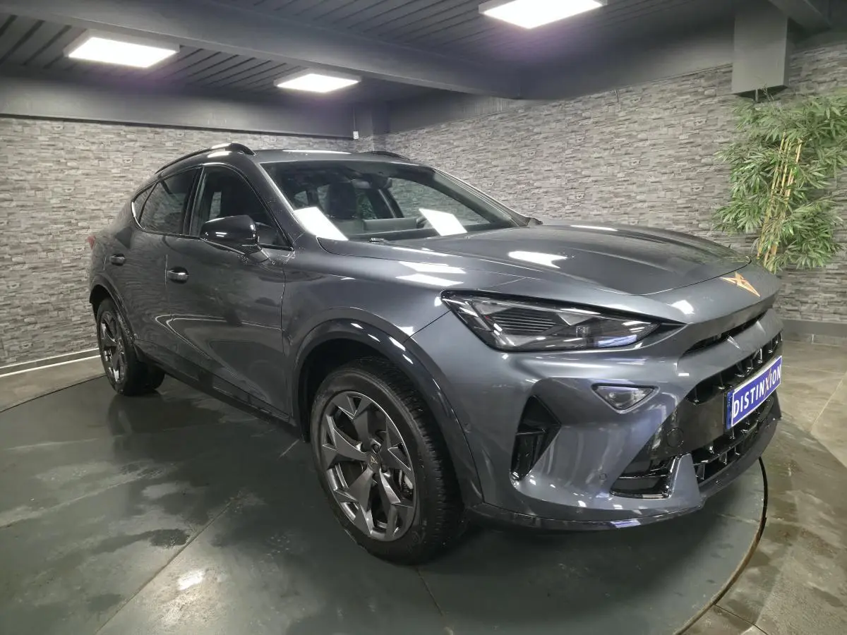 Vue 3/4 avant droit d'un CUPRA Formentor gris métallisé avec jantes alliage 18'' et signature lumineuse Tri-LED.