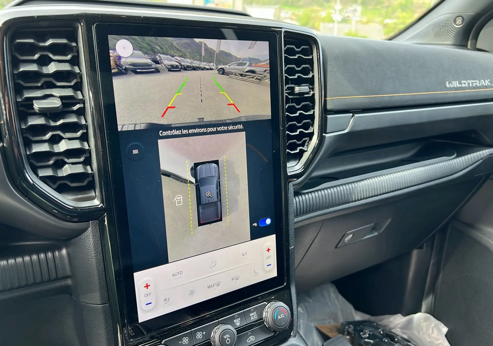 Vue rapprochée de l’écran central tactile du Ford Ranger Wildtrak X, avec affichage caméra 360° et tableau de bord noir.