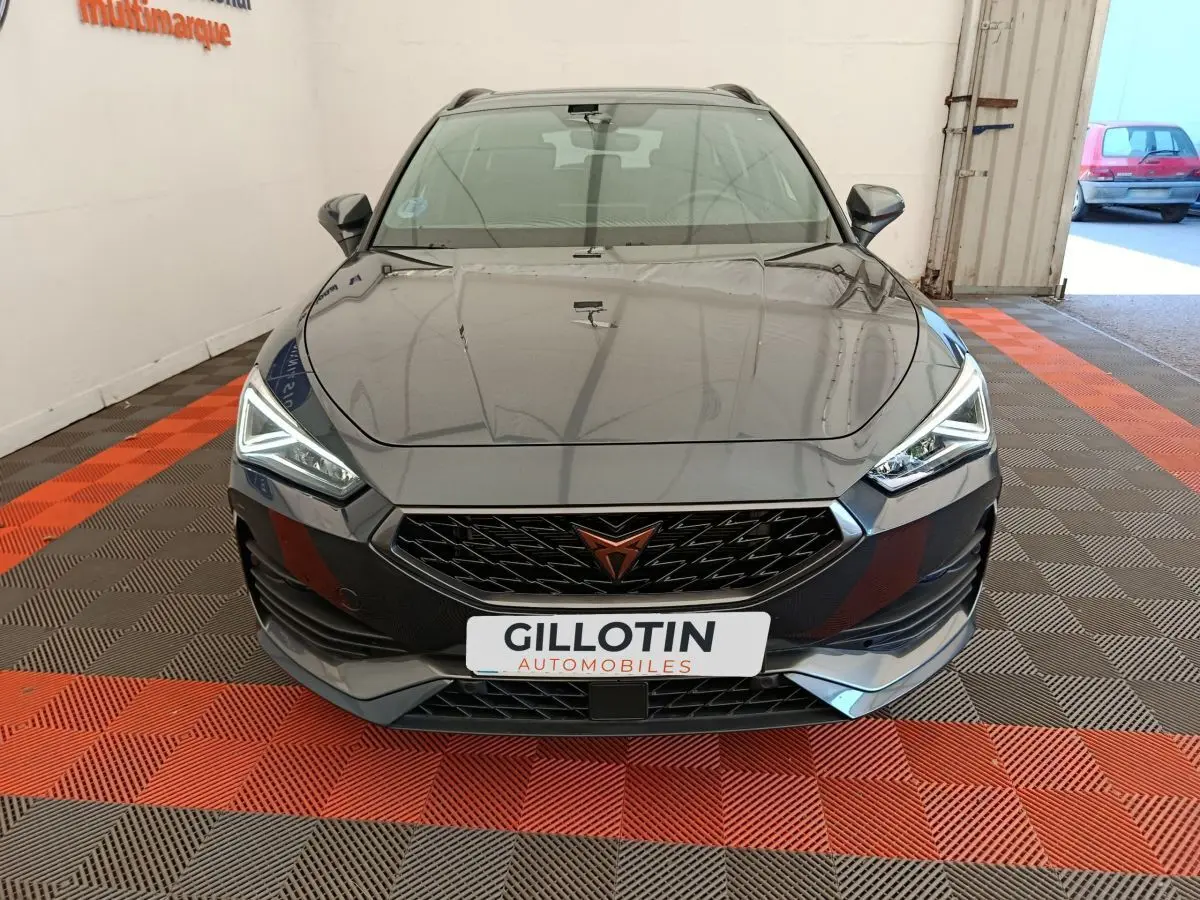 Vue frontale d'une CUPRA LEON ST 1.5 eTSI gris foncé avec phares LED et calandre noire distinctive.