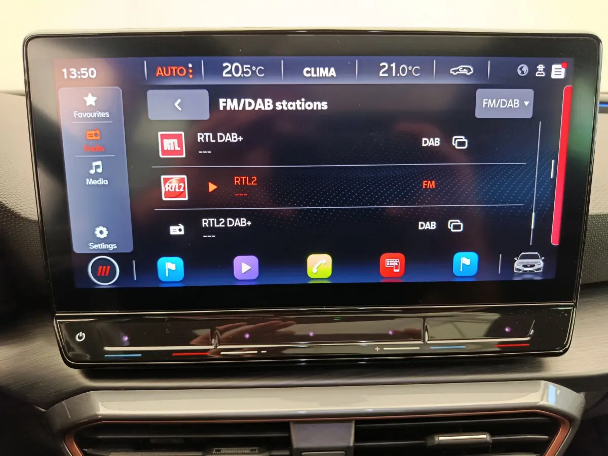 Écran tactile central de 12 pouces affichant les stations radio dans l'habitacle du CUPRA LEON ST gris foncé 2024.