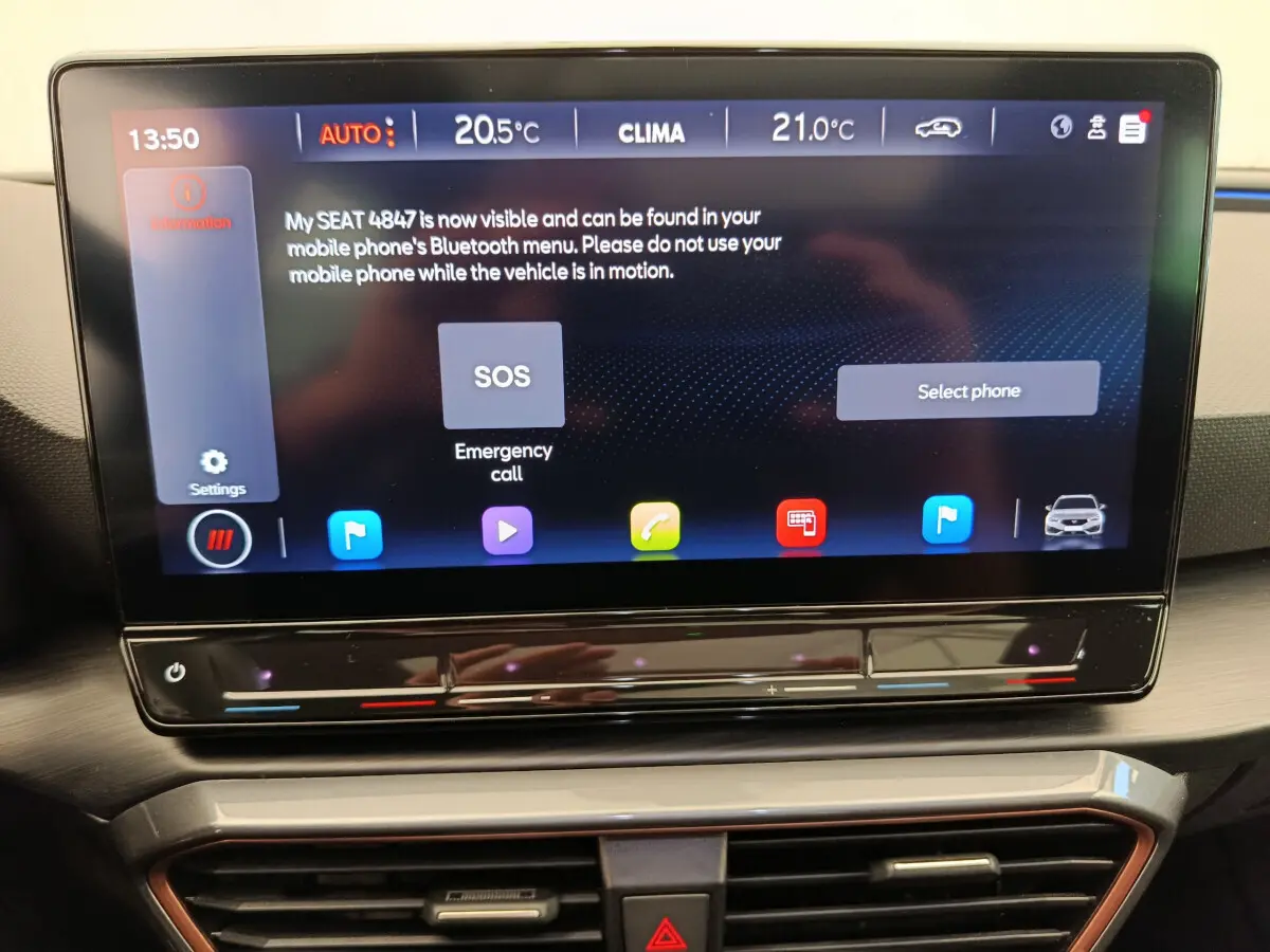 Écran tactile central 12 pouces du tableau de bord de la CUPRA LEON ST 2024 affichant les commandes climatiques et d'appel d'urgence.