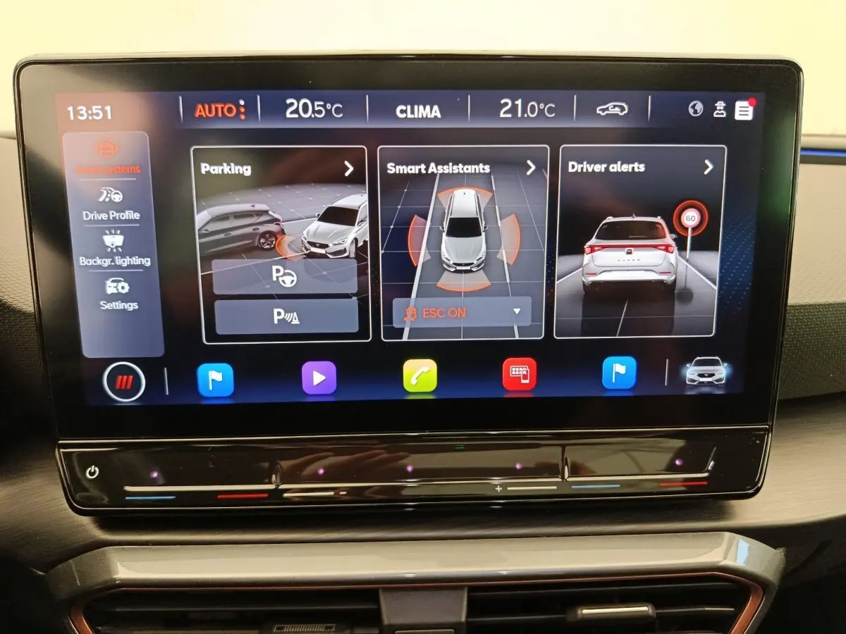 Écran tactile central de la CUPRA LEON ST 2024 affichant aides à la conduite et réglages climatiques.