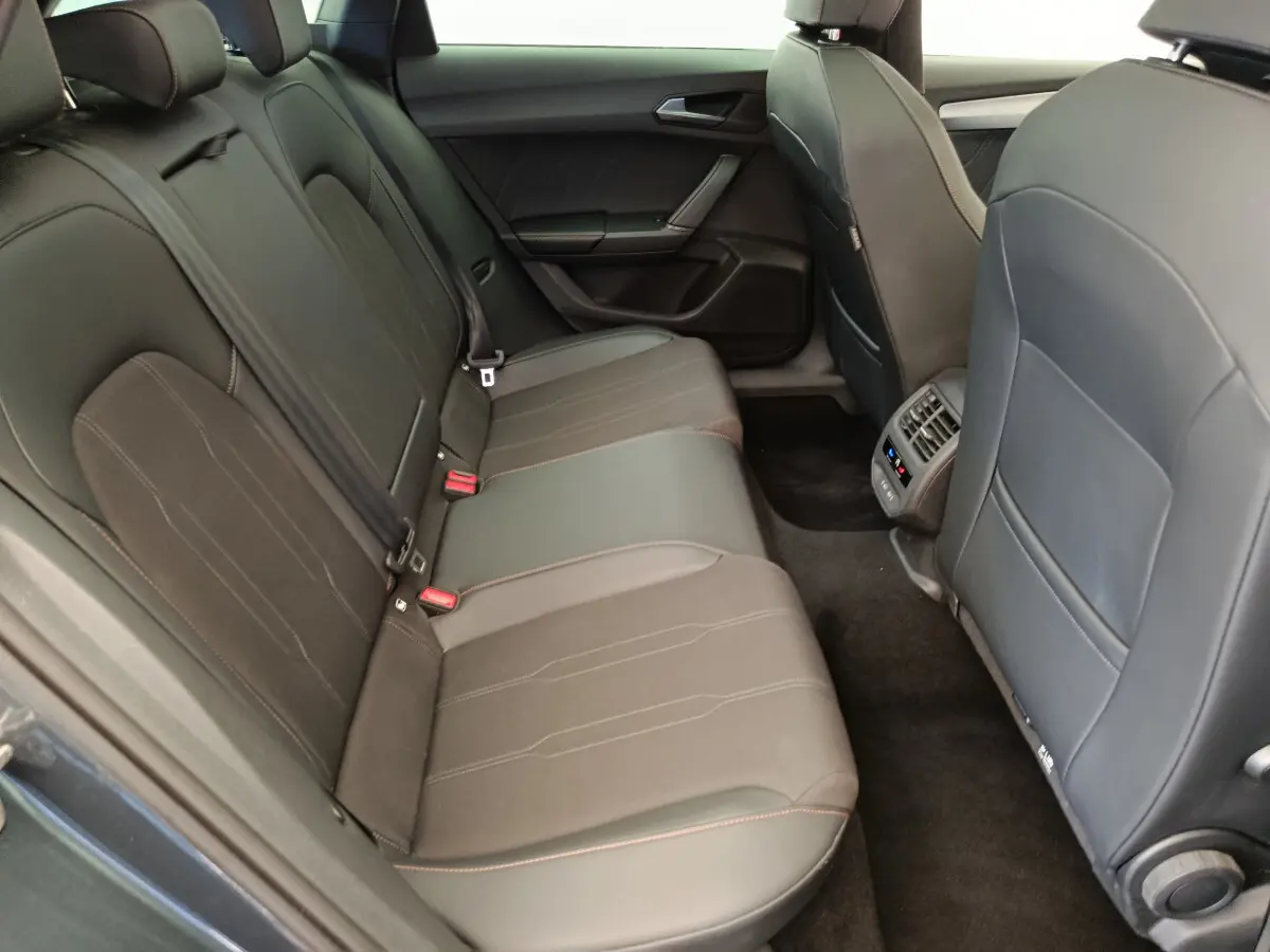 Vue intérieure côté droit des sièges arrière en cuir noir du CUPRA LEON ST 1.5 eTSI 2024 avec console de climatisation arrière.