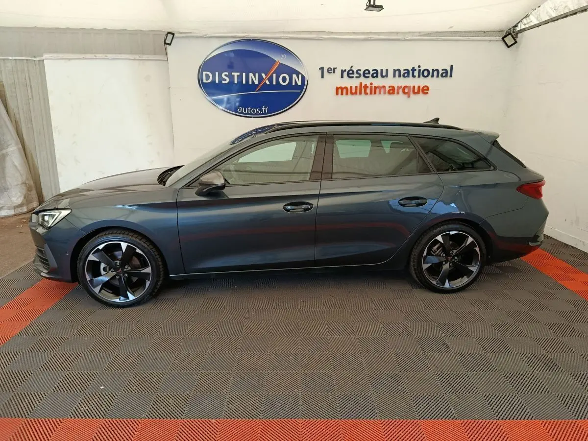 Profil côté gauche d'une CUPRA LEON ST gris foncé 2024, avec jantes noires et détails sportifs visibles.