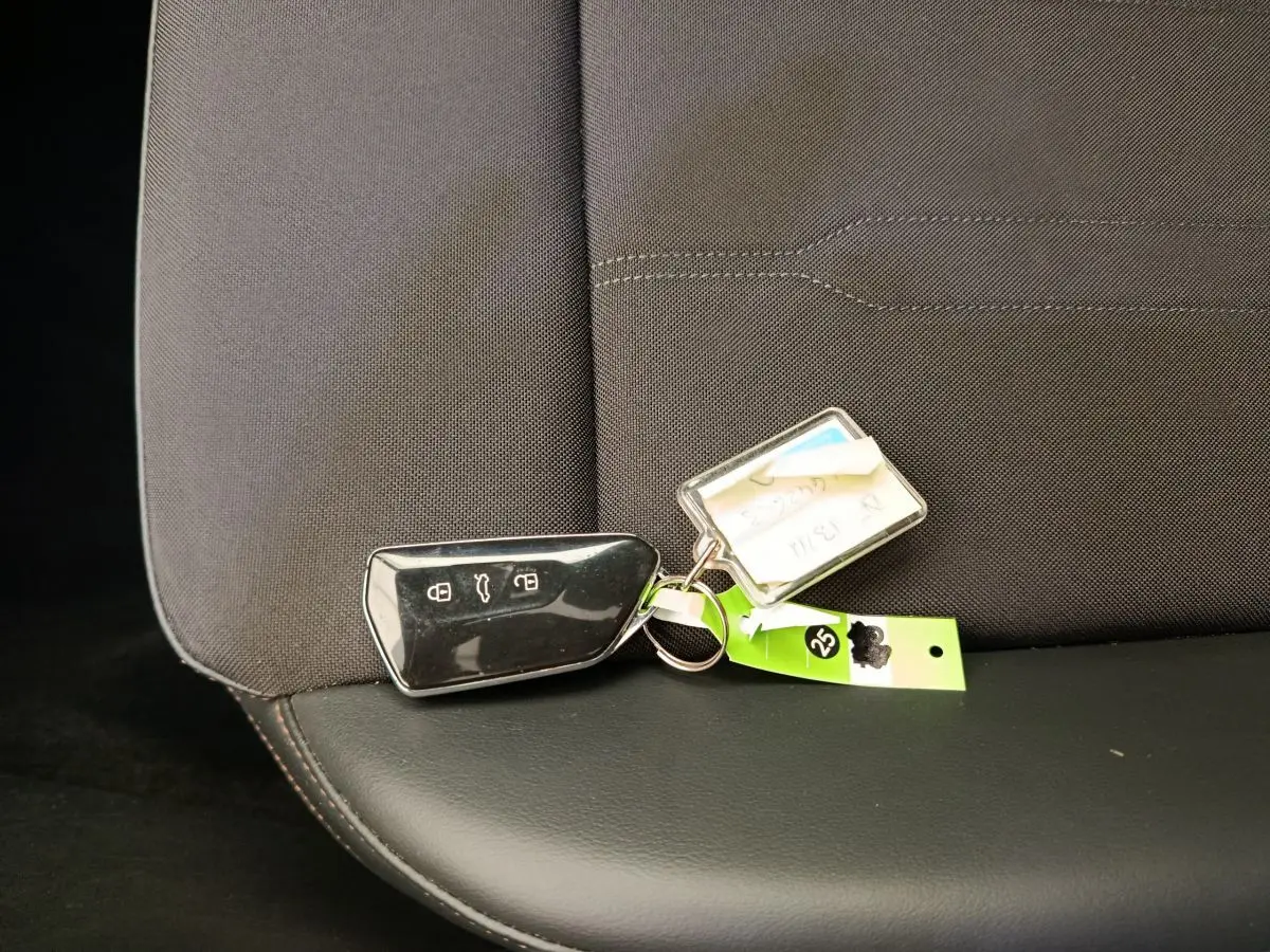 Télécommande noire posée sur la banquette arrière en tissu gris foncé et cuir noir d'une CUPRA LEON ST 2024.