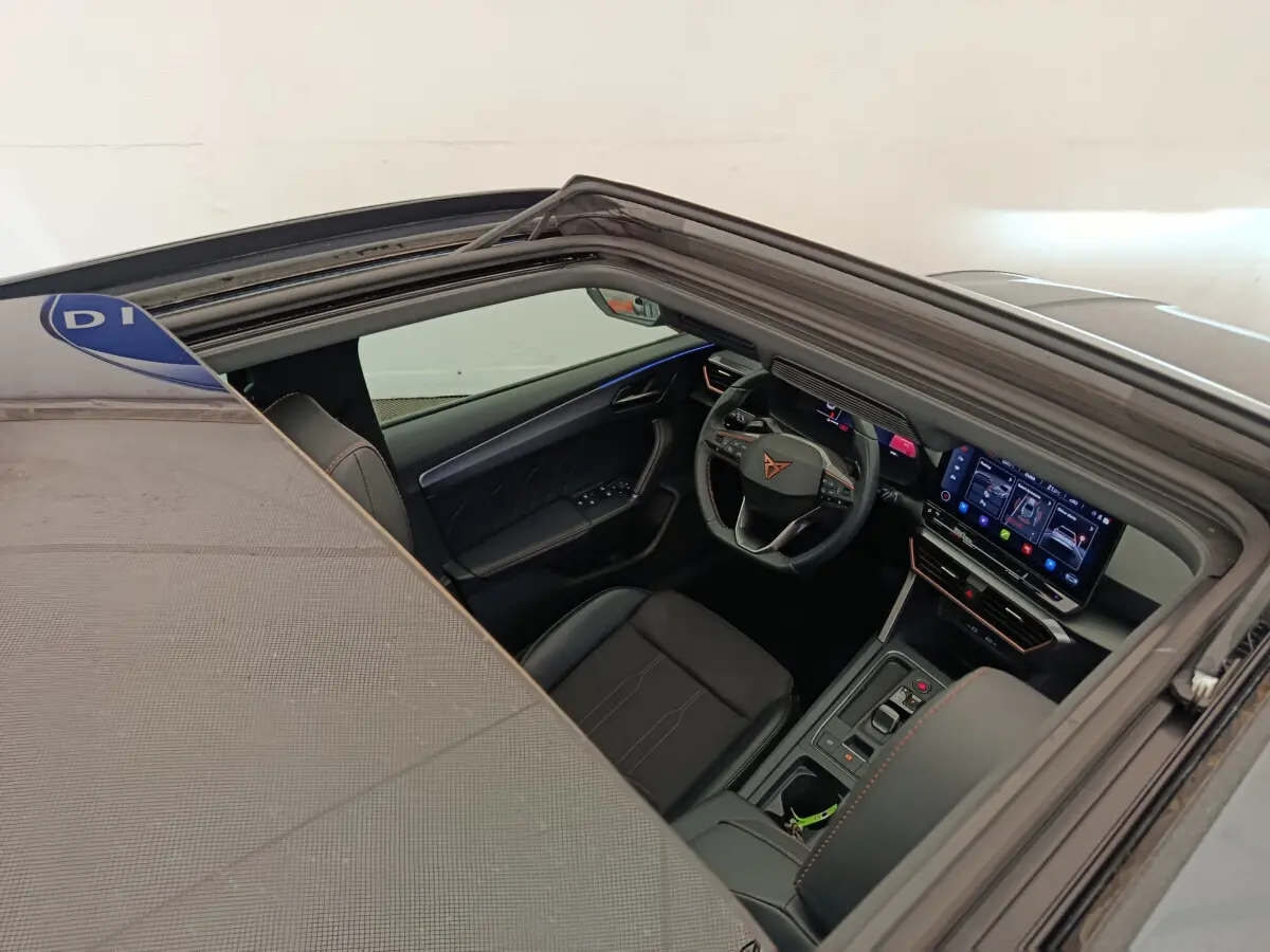 Vue intérieure côté conducteur de la CUPRA LEON ST gris foncé, avec tableau de bord digital et volant multifonctions.