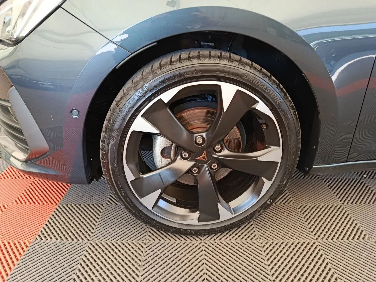 Gros plan sur la roue avant gauche gris foncé d'une CUPRA LEON ST 1.5 eTSI 150 DSG7 V avec jante noire et argentée distinctive.