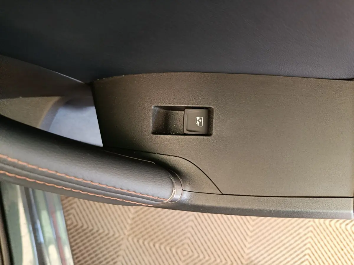Gros plan sur le bouton de commande de vitre électrique sur la porte côté conducteur d'une CUPRA LEON ST gris foncé 2024.