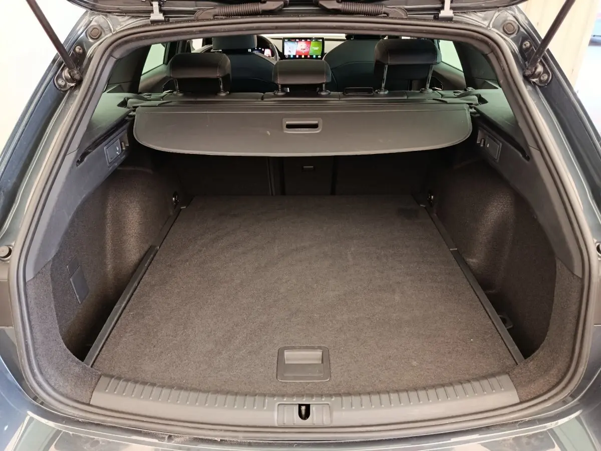 Coffre ouvert d'une CUPRA LEON ST gris foncé, vue arrière montrant l'espace de chargement et la tablette de séparation.