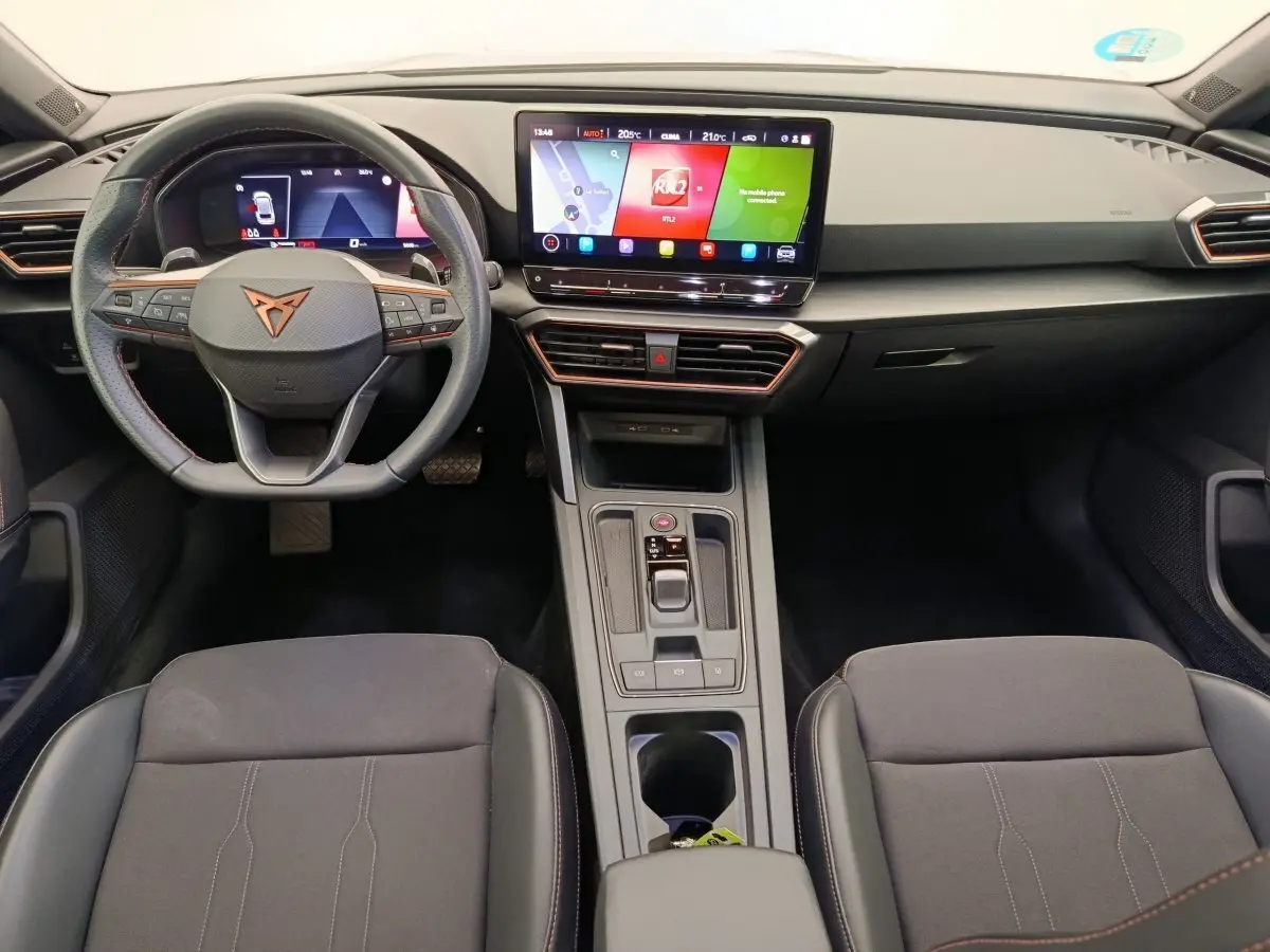 Intérieur de la CUPRA LEON ST 2024, vue frontale du tableau de bord avec écran tactile central et volant cuir noir.