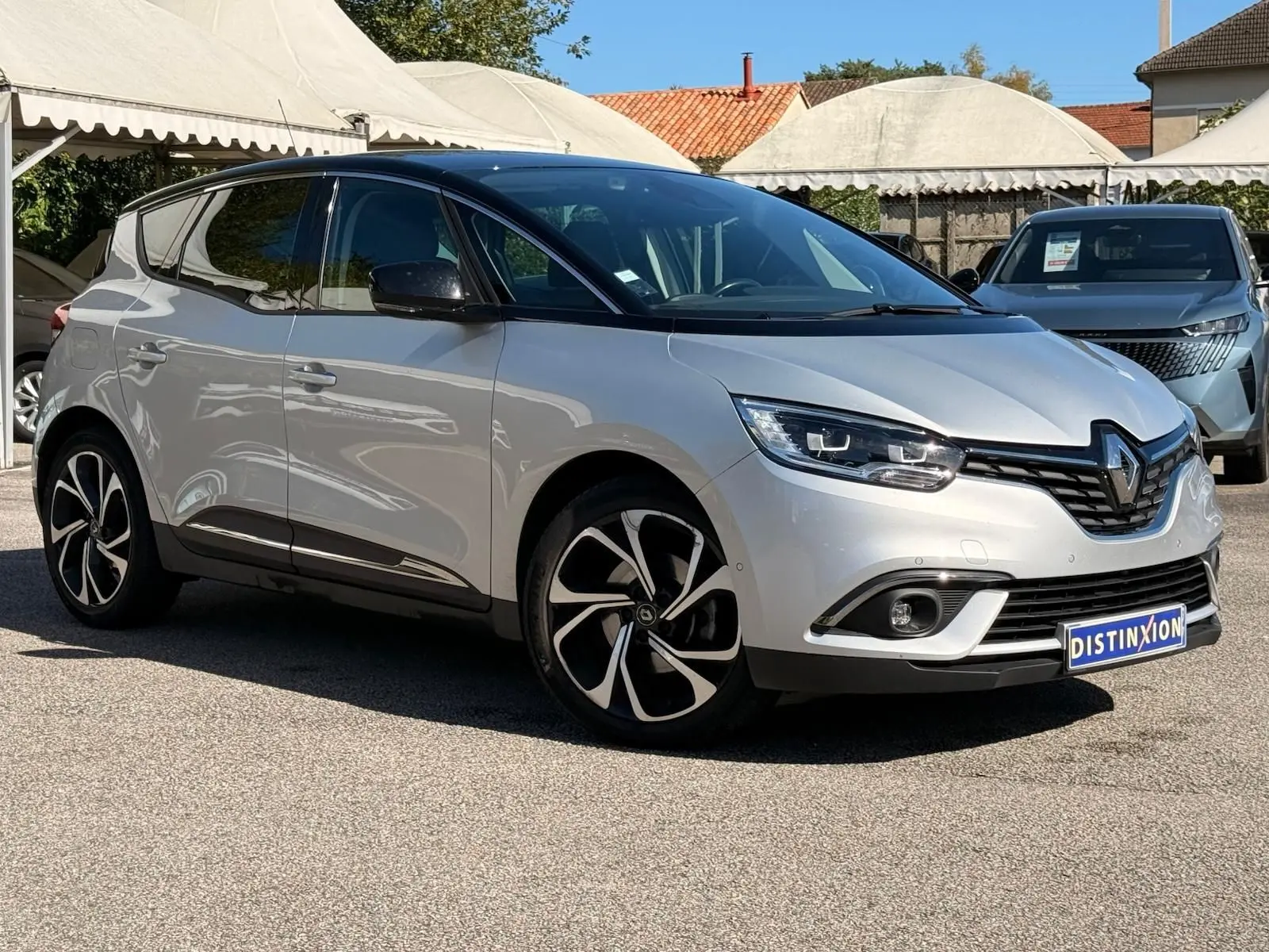 Renault Scénic IV gris platine avec toit noir, vue 3/4 avant droit, jantes noires et blanches distinctives.