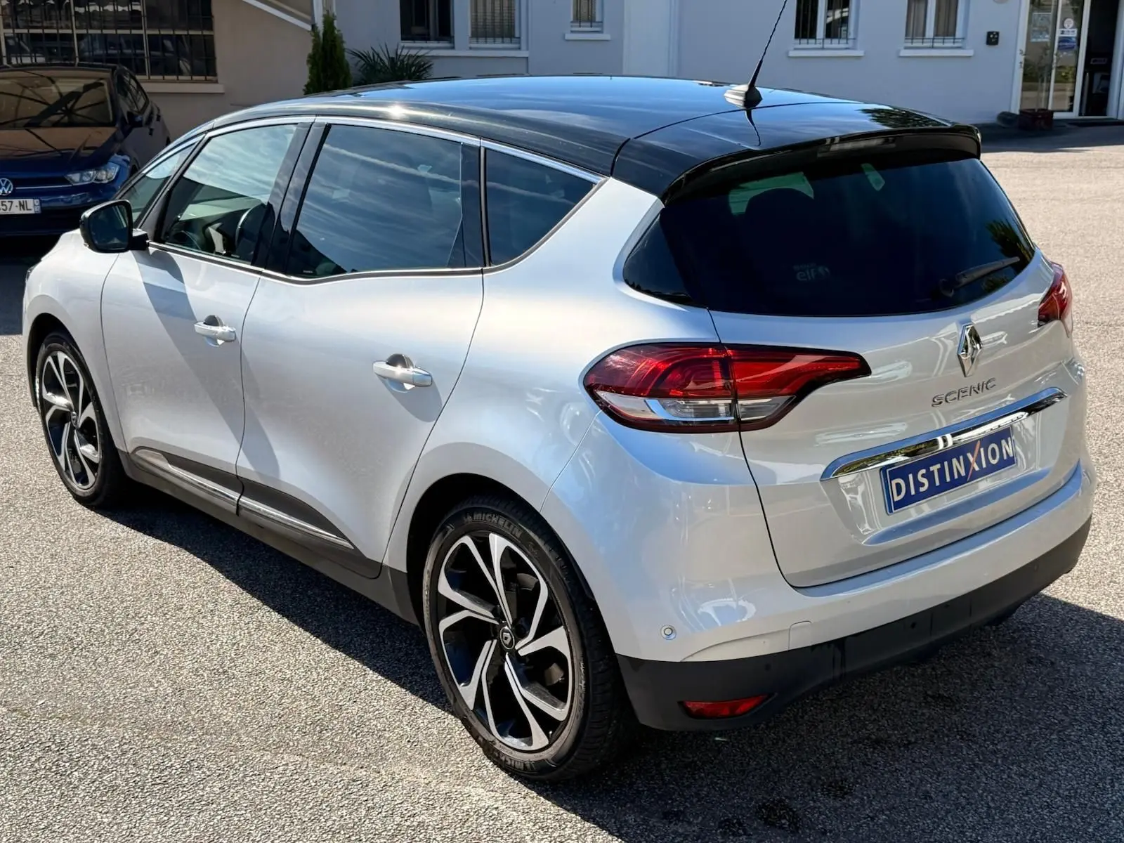 Vue 3/4 arrière droite du Renault Scénic IV gris platine avec toit noir étoile et jantes alliage distinctives.