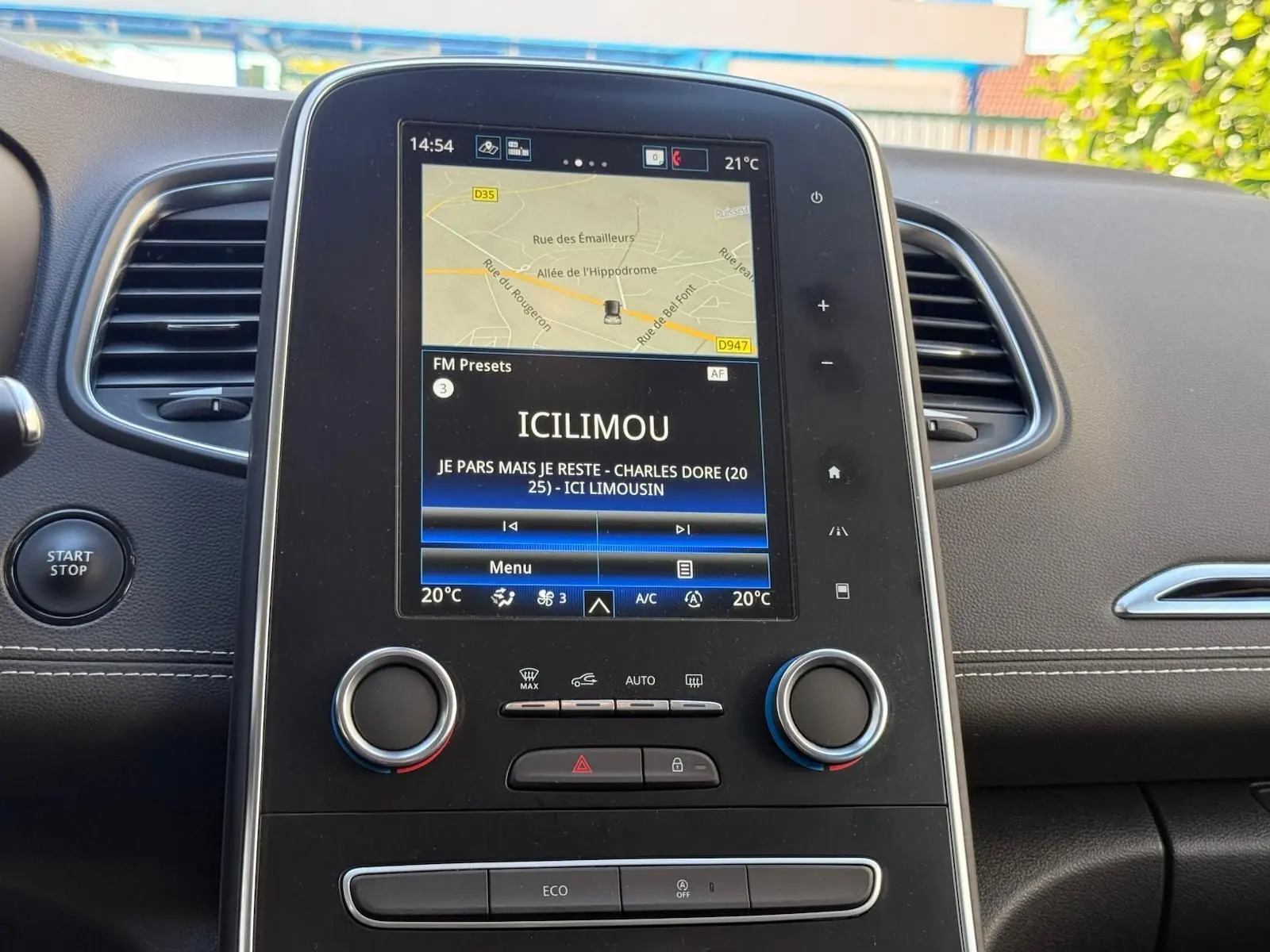 Tableau de bord du Renault Scenic IV 2020, avec écran tactile central affichant la navigation et la radio, ambiance intérieure noire.