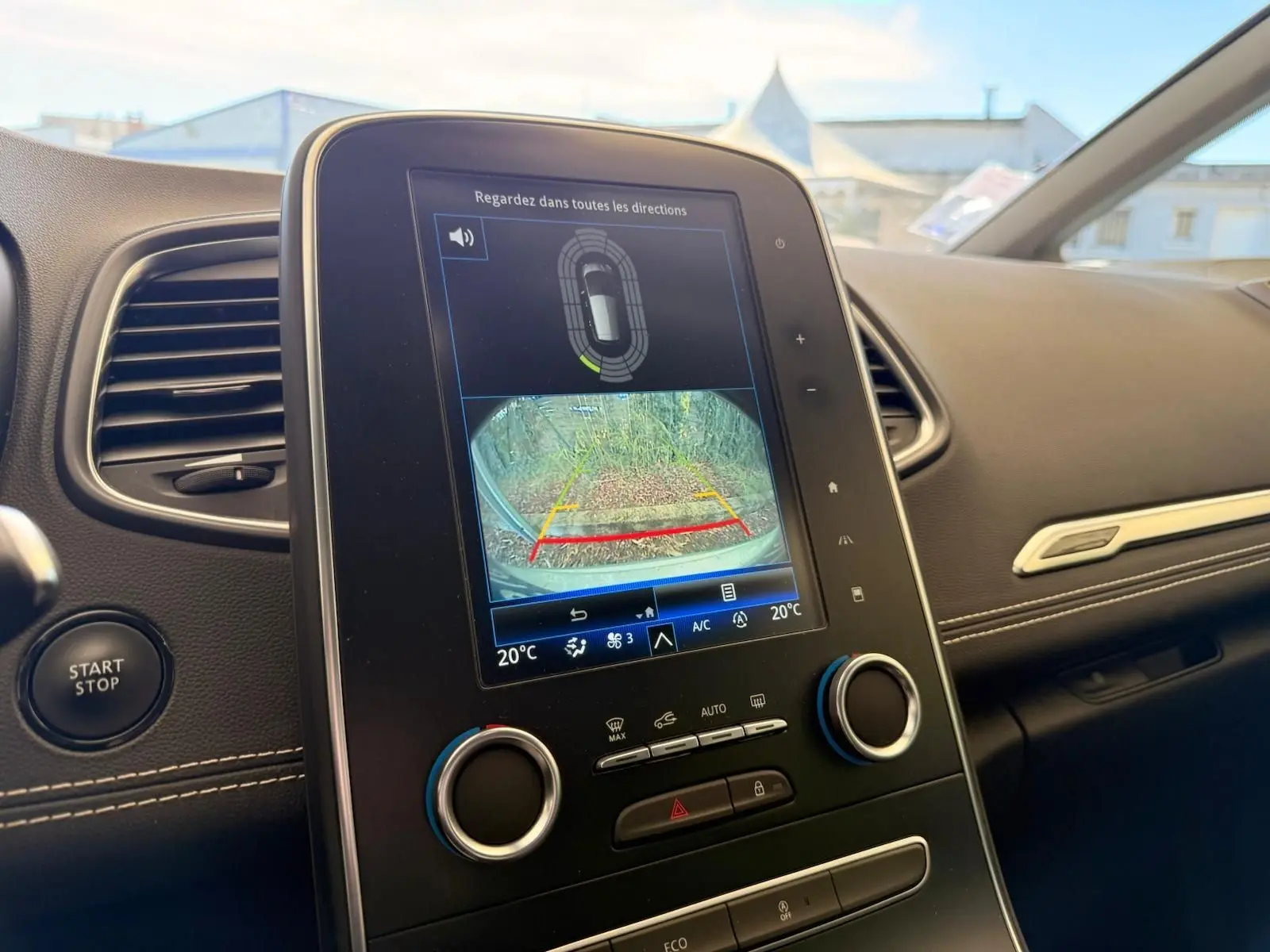 Vue intérieure du tableau de bord du Renault Scenic IV 2020, écran tactile affichant la caméra de recul et commandes climatisation.