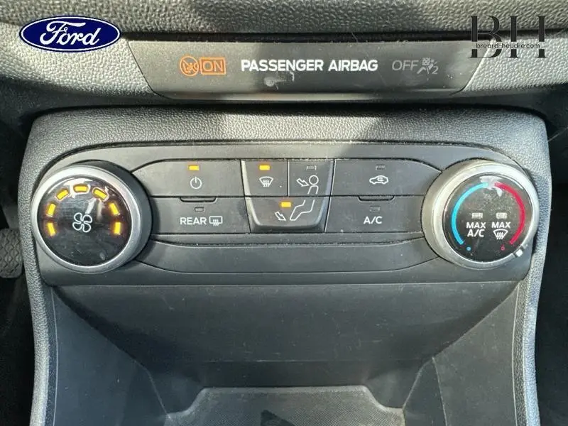 Vue rapprochée du tableau de bord de la Ford Fiesta 2020, montrant les commandes de climatisation et l'indicateur d'airbag passager actif.
